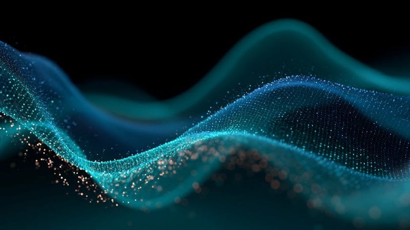 Abstract flowing wave of glowing blue and cyan particles on a dark background